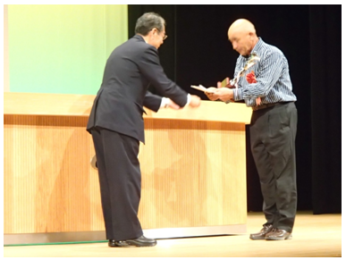 鹿児島県糖業振興協会主催「平成25年度さとうきび生産改善共励会」鹿児島県糖業振興会理事長賞を授与される種子島地区代表生産者 砂坂浩一郎氏(右)