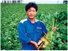 自慢のてん菜を持つ桑迫孝幸さん